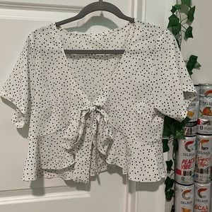 white polka dotted top with a tie in the front